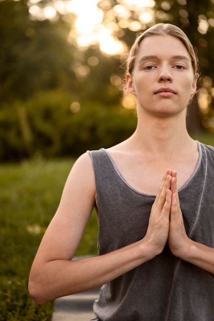 Вид спереди женщина медитирует на открытом воздухе