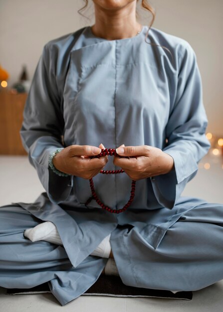 Вид спереди женщины, медитирующей с бусами