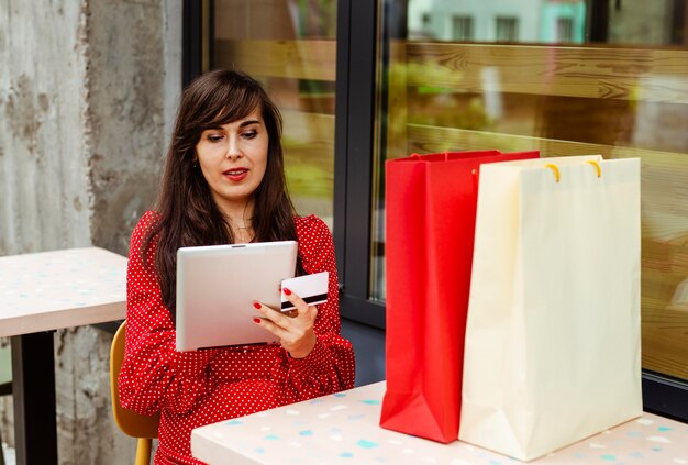 Foto gratuita vista frontale della donna che ordina gli articoli in vendita utilizzando tablet