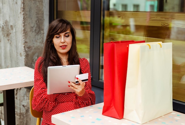 Вид спереди женщины, заказывающей товары на распродаже с помощью планшета