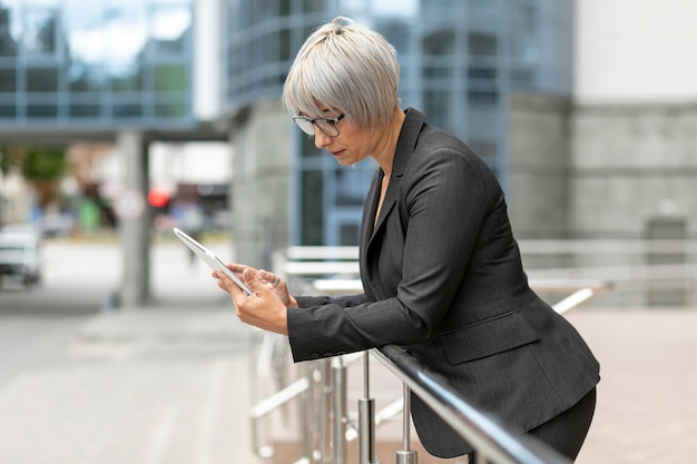 Front view woman outdoor looking on tablet