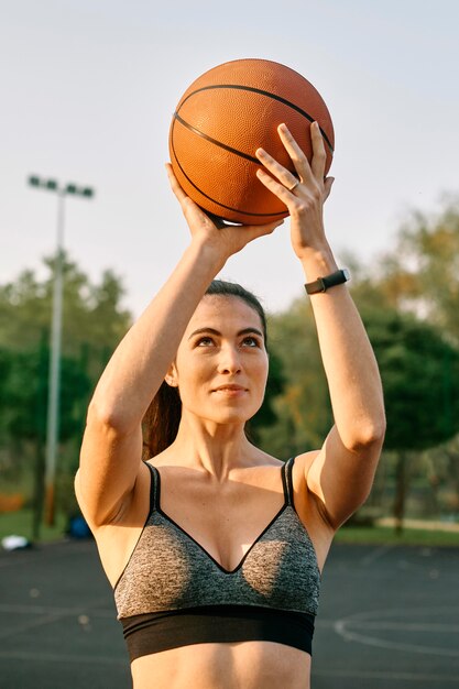 Front view woman playing basketball alone