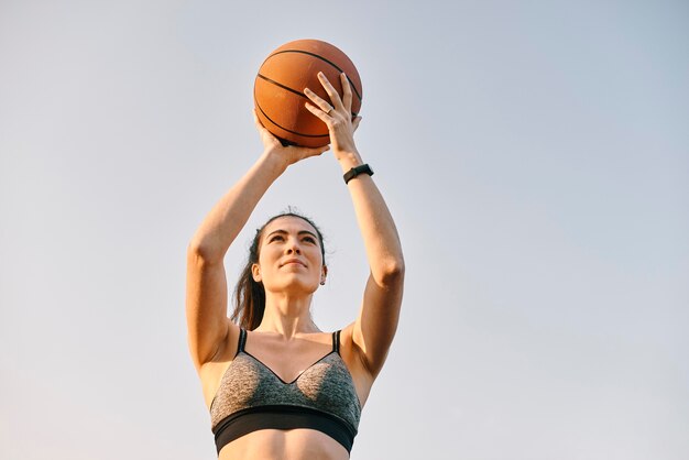 Front view woman playing basketball alone