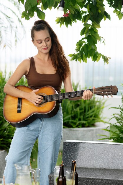 Вид спереди женщина играет на гитаре