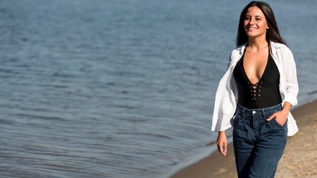 Front view of woman posing on the beach with copy space