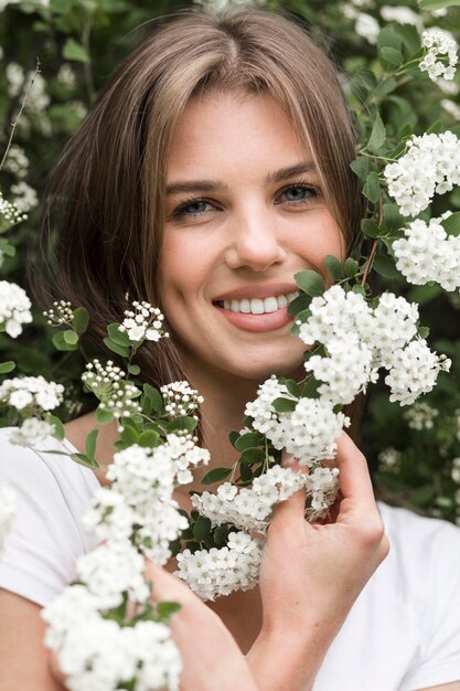 Front view woman posing in flowers