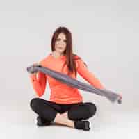 Free photo front view of woman posing in gym attire while holding towel