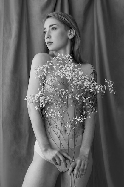 Front view woman posing nude with flowers