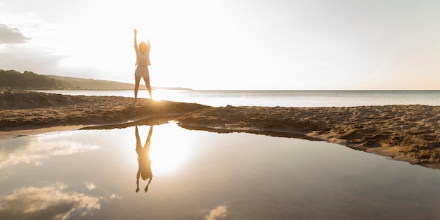 Front view of woman posing outdoors with water