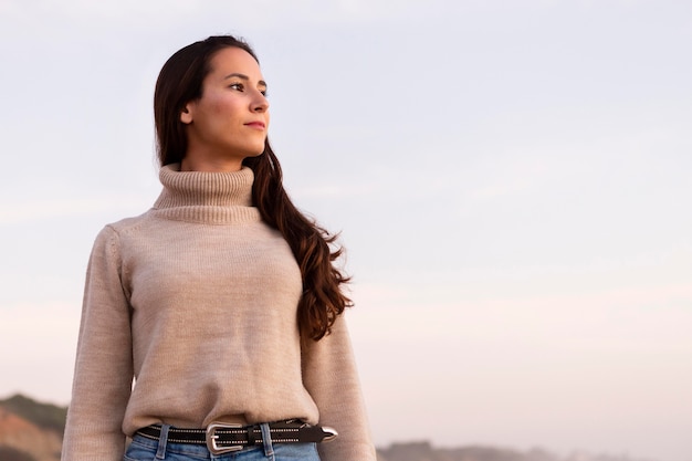 Free photo front view of woman posing stoic by the beach with copy space