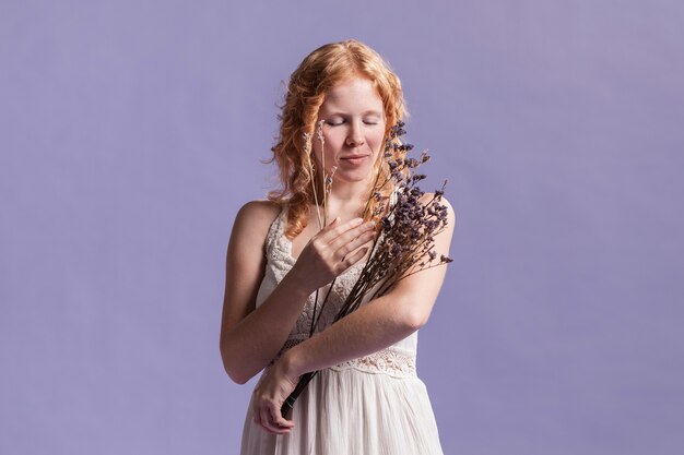 Front view of woman posing while holding a bouquet of lavender