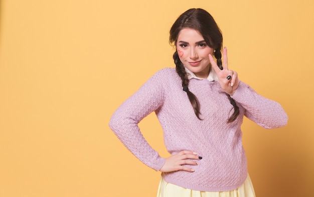 Front view of woman posing while showing peace sign