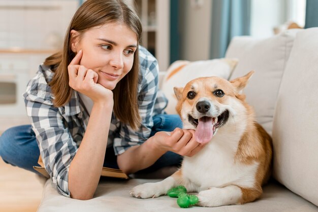 Front view of woman posing with dog on couch
