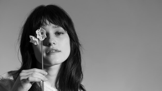 Front view woman posing with flower