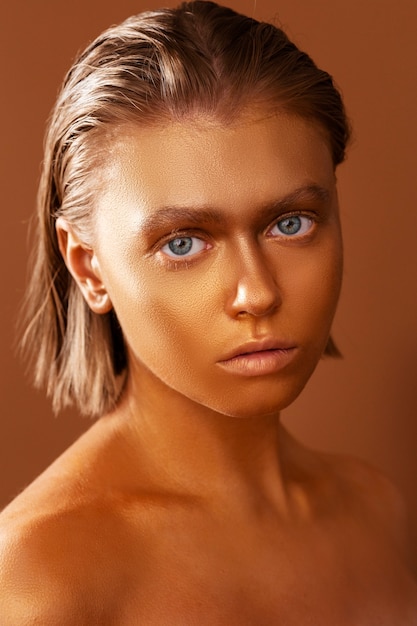 Front view woman posing with gold body painting