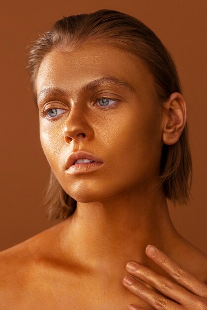 Front view woman posing with gold body painting