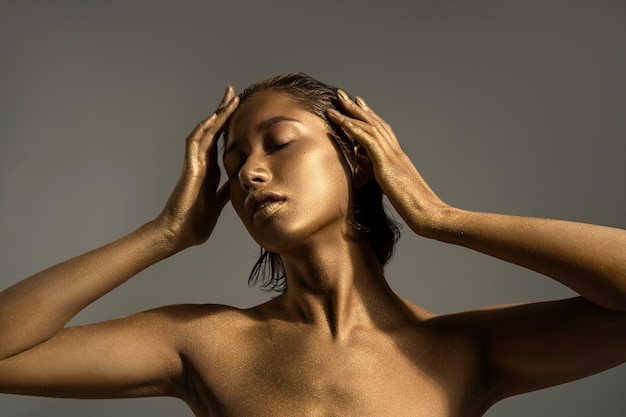 Front view woman posing with gold body painting