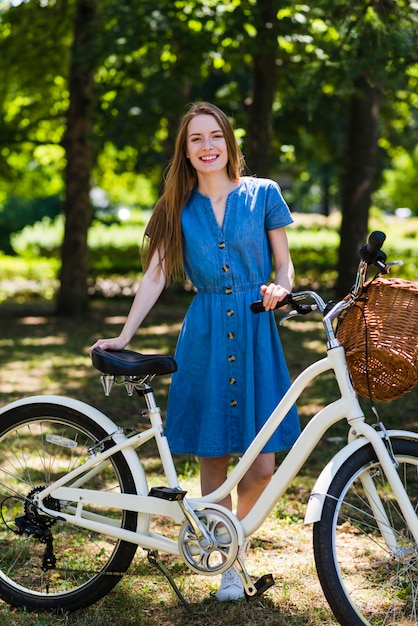 フロントビュー女性が彼女の自転車でポーズ