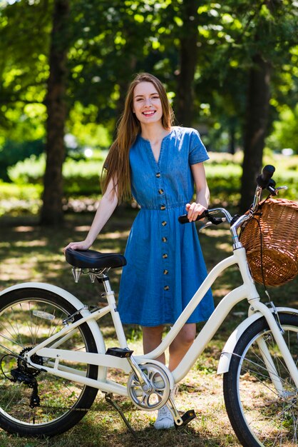 フロントビュー女性が彼女の自転車でポーズ