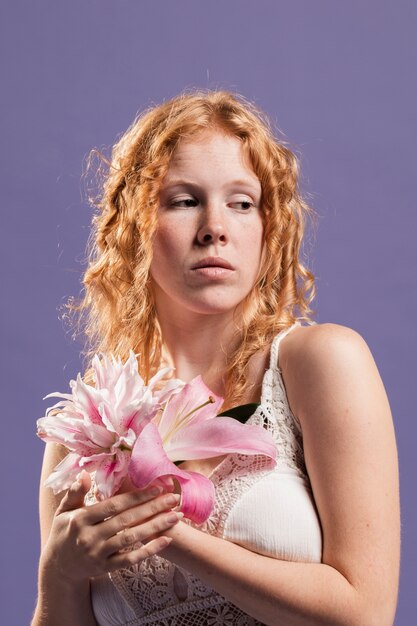 Front view of woman posing with lily and peony