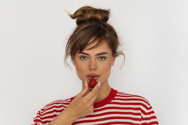 Front view woman posing with strawberry