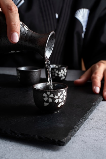 Front view woman pouring drink in cup