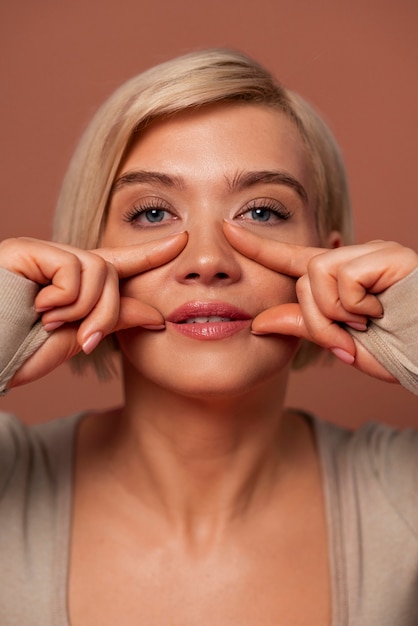 Free photo front view woman practicing facial yoga