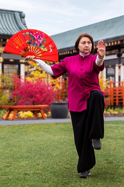 Front view woman practicing tai chi outdoors
