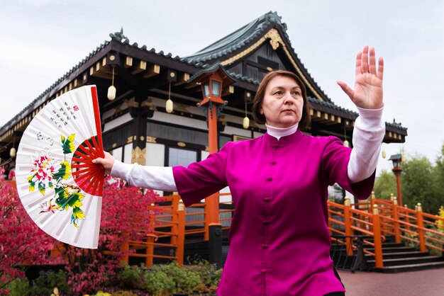 Front view woman practicing tai chi outdoors