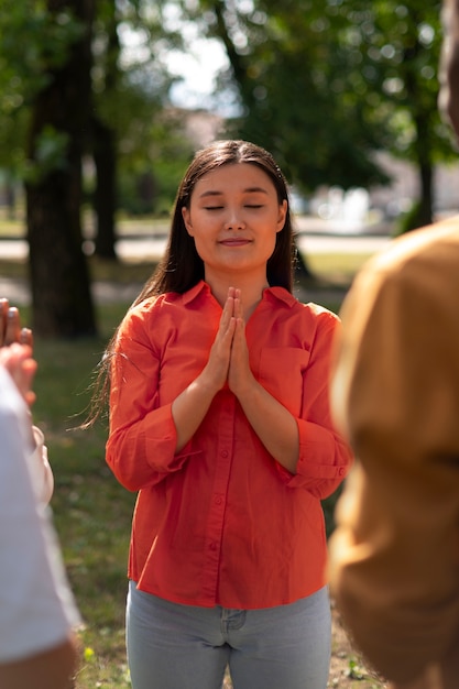 Free photo front view  woman praying outdoors