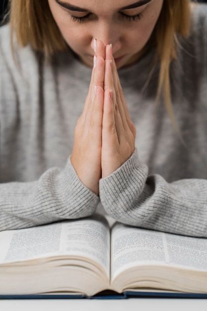 Foto gratuita vista frontale della donna che prega con la bibbia