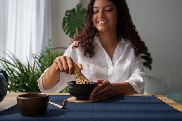 自宅で青い抹茶を準備する正面図の女性
