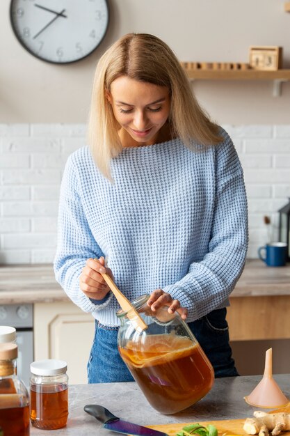 front view woman preparing kombucha