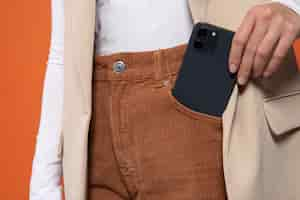 Free photo front view of woman putting or taking out her smartphone from her pocket