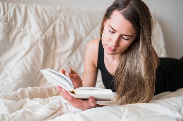 침대에서 독서하는 여자의 전면 모습