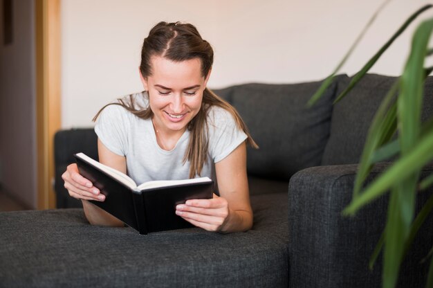 Вид спереди женщины, читающей книгу