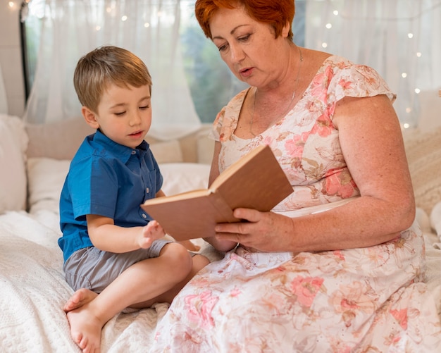 Front view woman reading to her grandson in a caravan