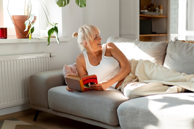 Foto gratuita donna di vista frontale che legge a casa