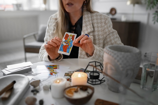 Free photo front view woman reading tarot at home