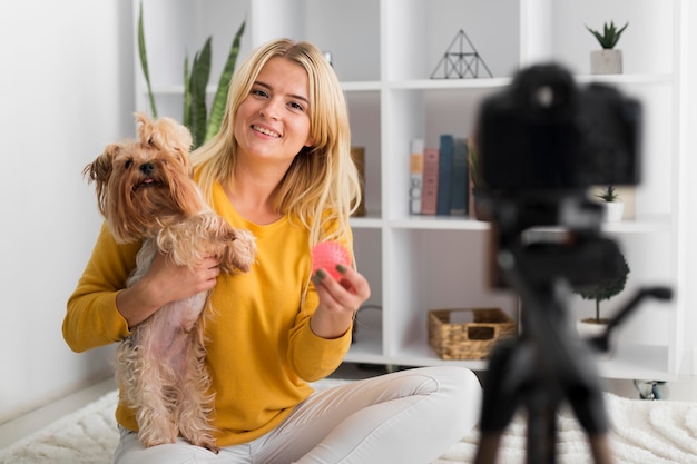 Foto gratuita donna di vista frontale che registra video con il suo animale domestico