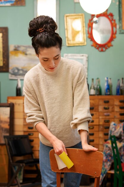 Front view woman restoring wooden chair