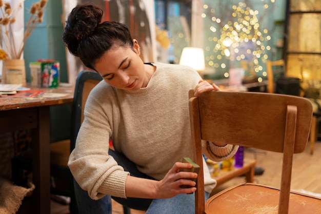 Front view woman restoring wooden chair