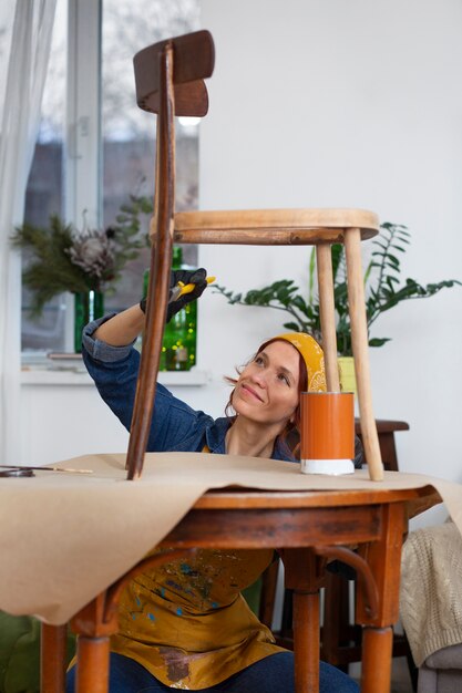 Бесплатное фото Женщина вид спереди восстанавливает деревянную мебель