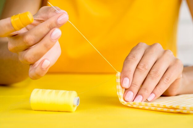 Front view of woman sewing textile