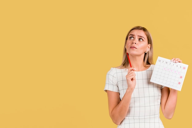 Front view woman showing her period calendar with copy space