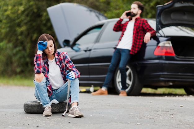 Front view of woman sitting on tire