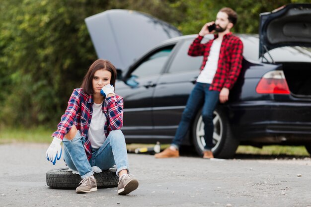 Front view of woman sitting on tyre