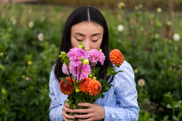 無料写真 花の匂いを嗅ぐ正面図の女性