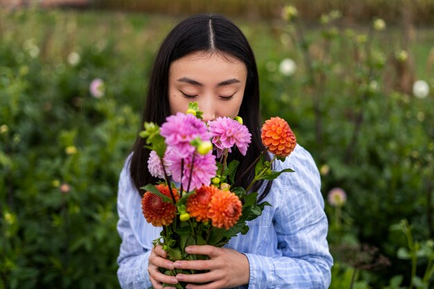 花の匂いを嗅ぐ正面図の女性
