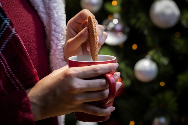 クッキーをお茶に浸すフロントビュー女性